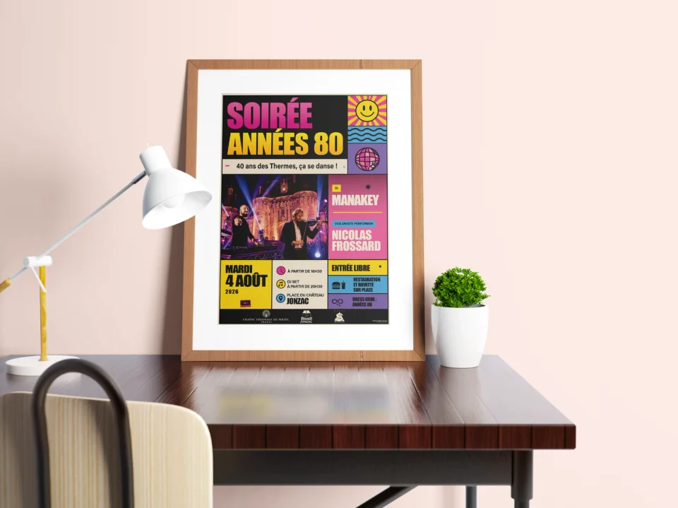 Affiche Soirée années 80 encadrée et posée sur un bureau avec une lampe et une plante.