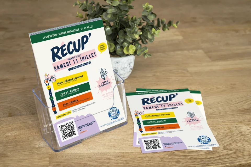 Flyers de l’événement RÉCUP’ disposés dans un présentoir transparent et sur un comptoir en bois.